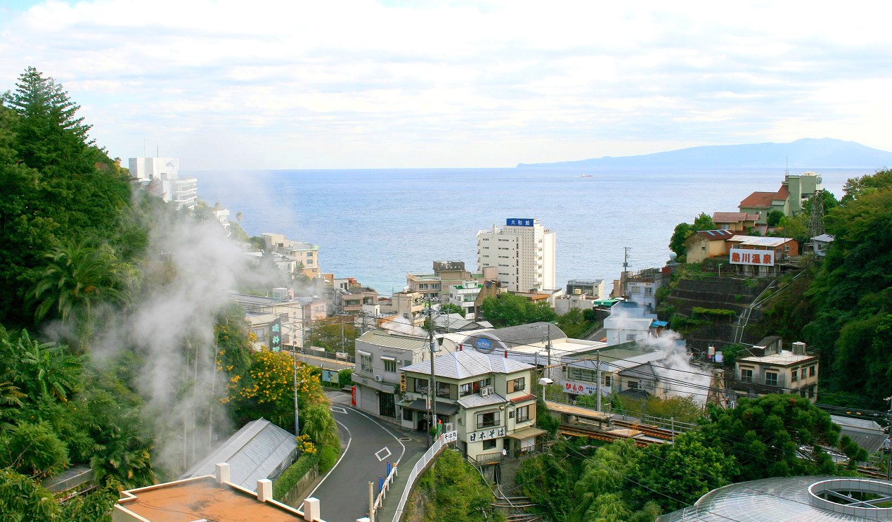 湯けむりが立ちのぼる熱川温泉の町並みと海