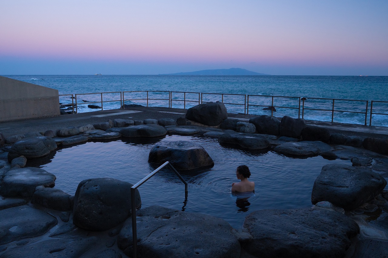 夕暮れの海と岩場の露天風呂