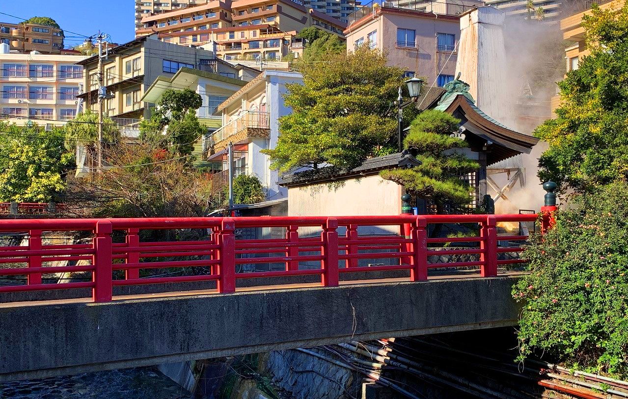 赤い欄干の橋と熱川温泉の町並み